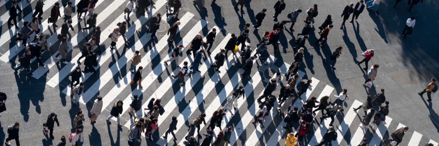 A crowd of people crossing a road.