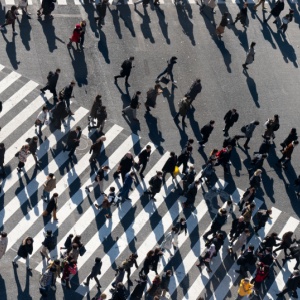 A crowd of people crossing a road.