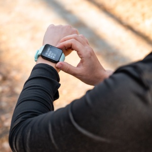 A runner looking at the time on their watch.