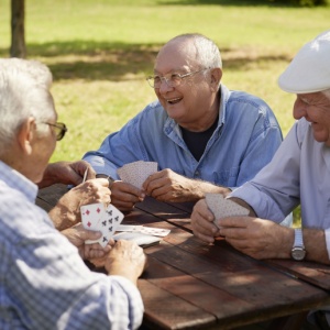 A group of friends playing cards outdoors.