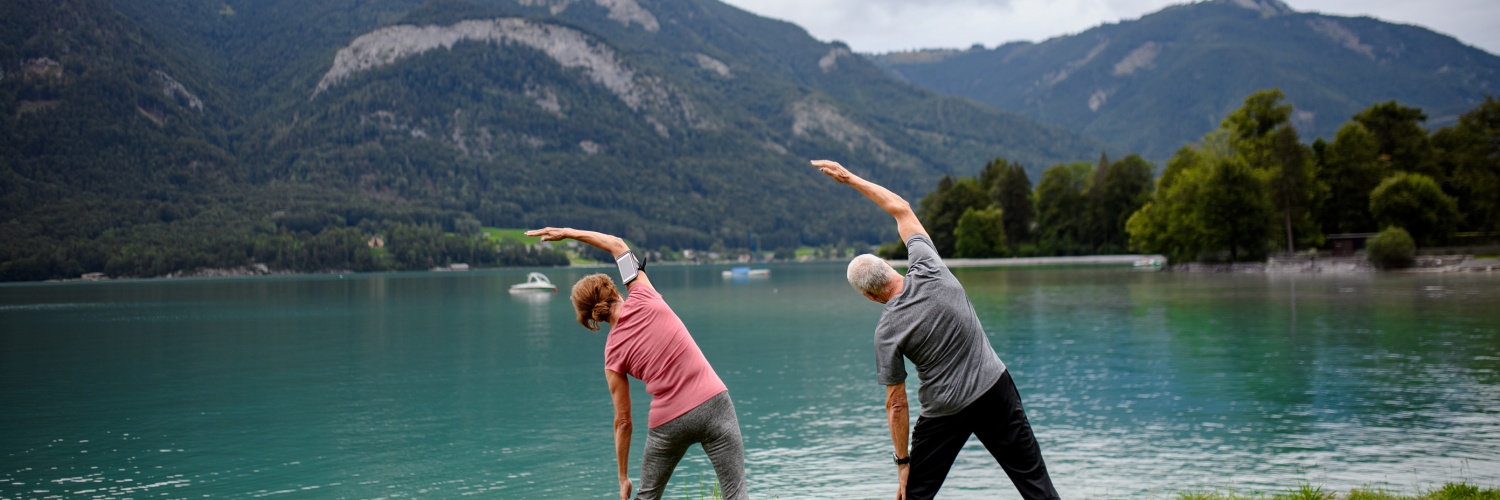 Couple doing tai chi by a lake