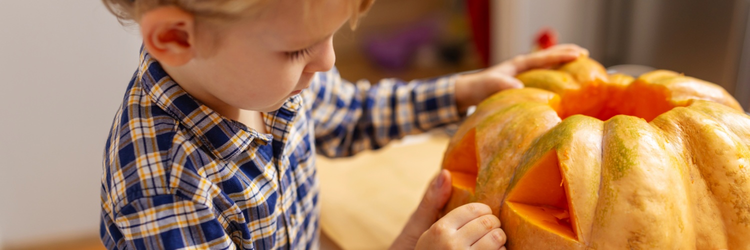 A child carving a pumpkin.